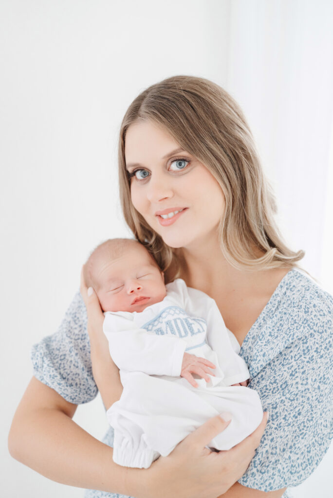 Mom cradles baby boy in Cumming newborn session.