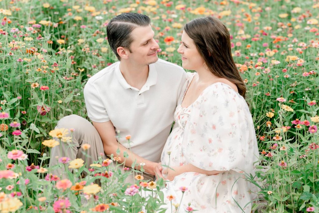 Husband and wife look lovingly at each other in a flower field at Prospect Farms.
