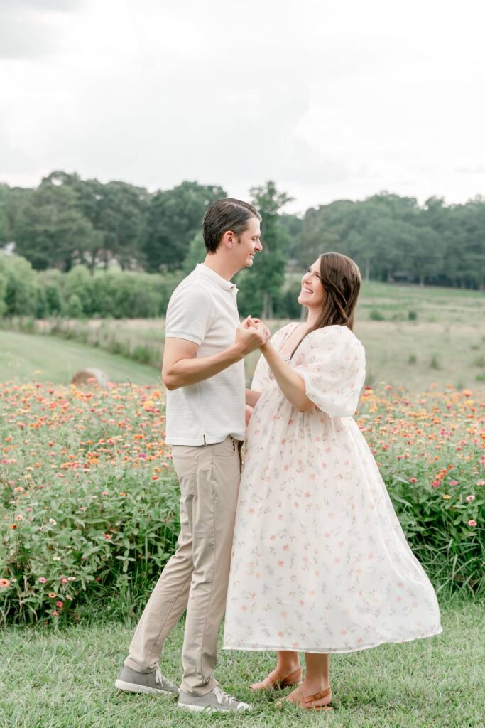Husband and wife dance with each other in a flower field at Prospect Farms.