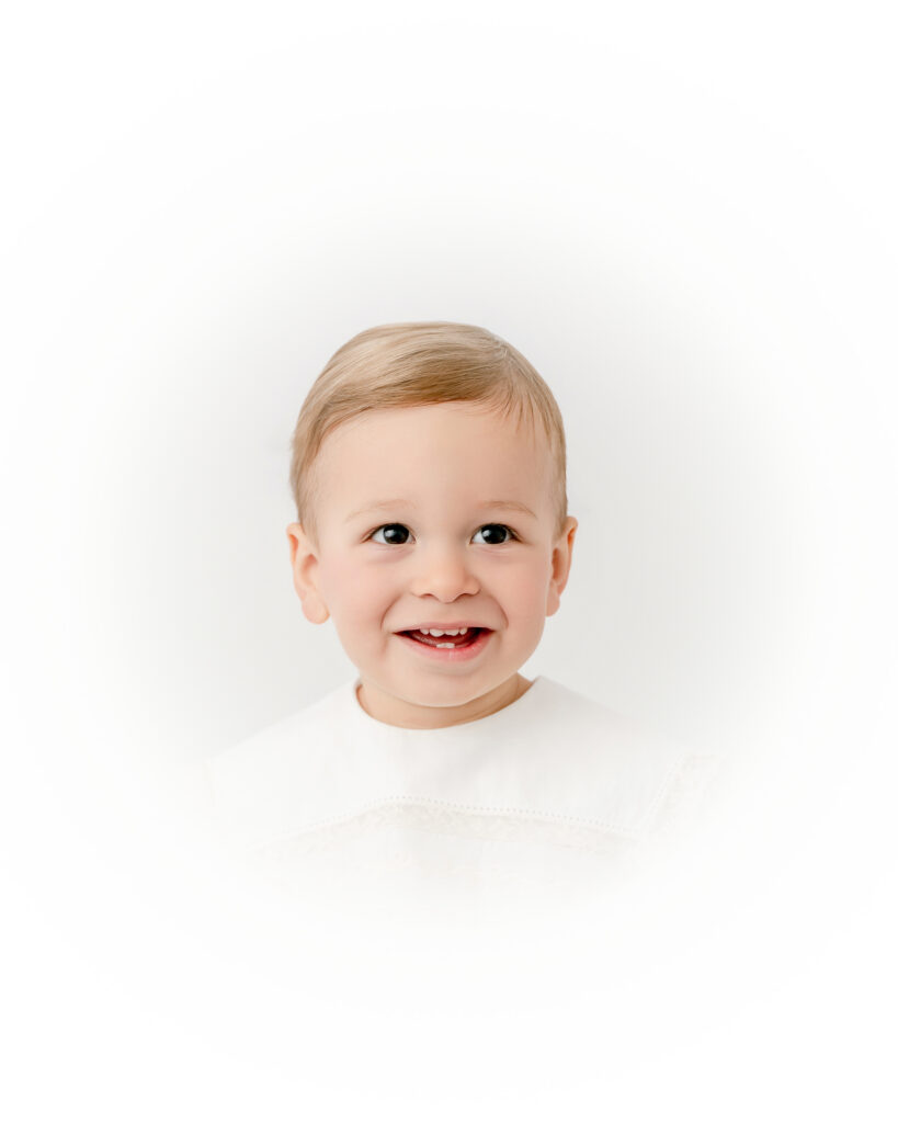 Little boy smiling during an Atlanta heirloom portrait session with a simple, classic backdrop