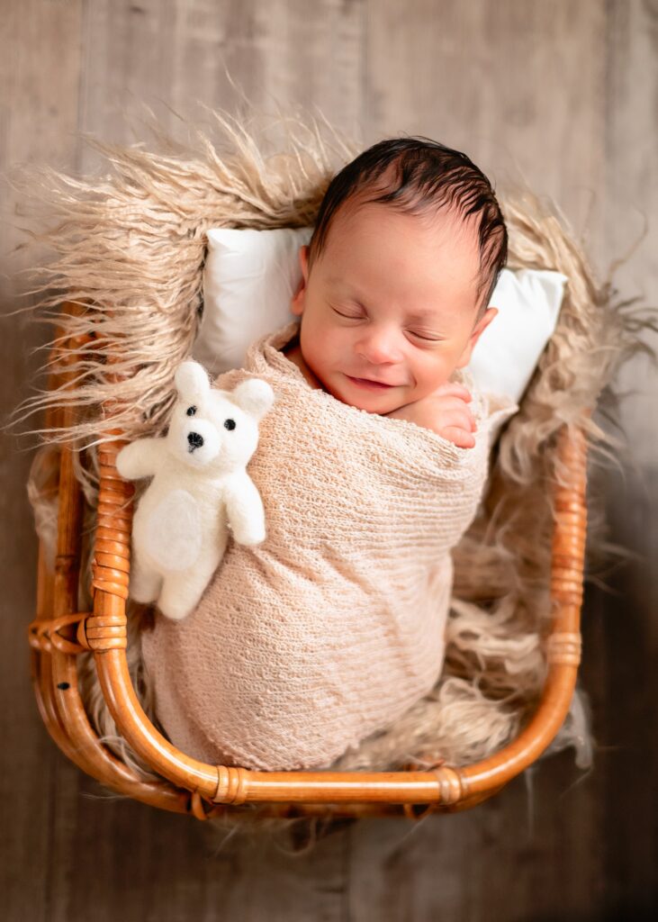 baby smiling in basket during newborn photography session in Cumming, GA