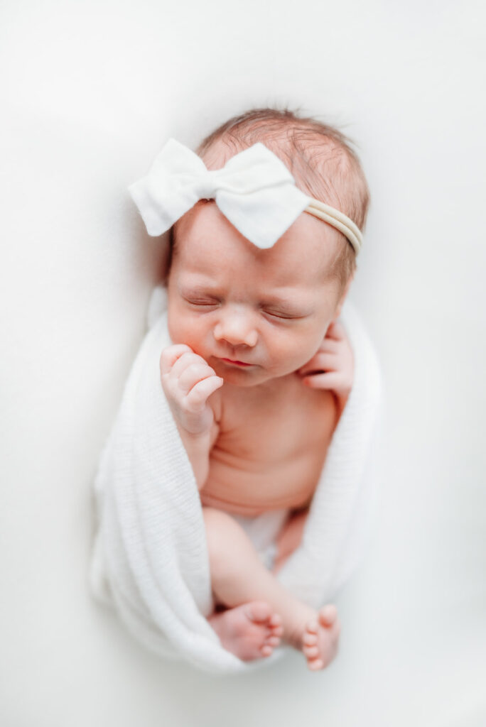 Baby girl in white blanket in studio newborn session with Scarlet Oak Photography in Cumming, GA