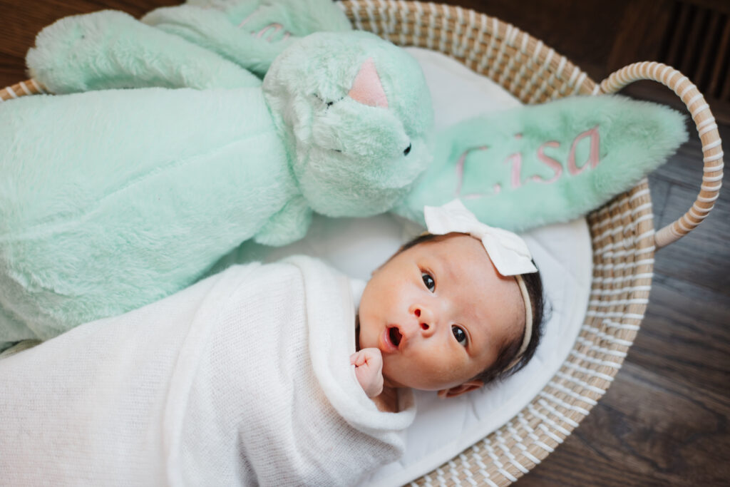 Baby wrapped in white blanket in lifestyle in home newborn session in Atlanta, Georgia