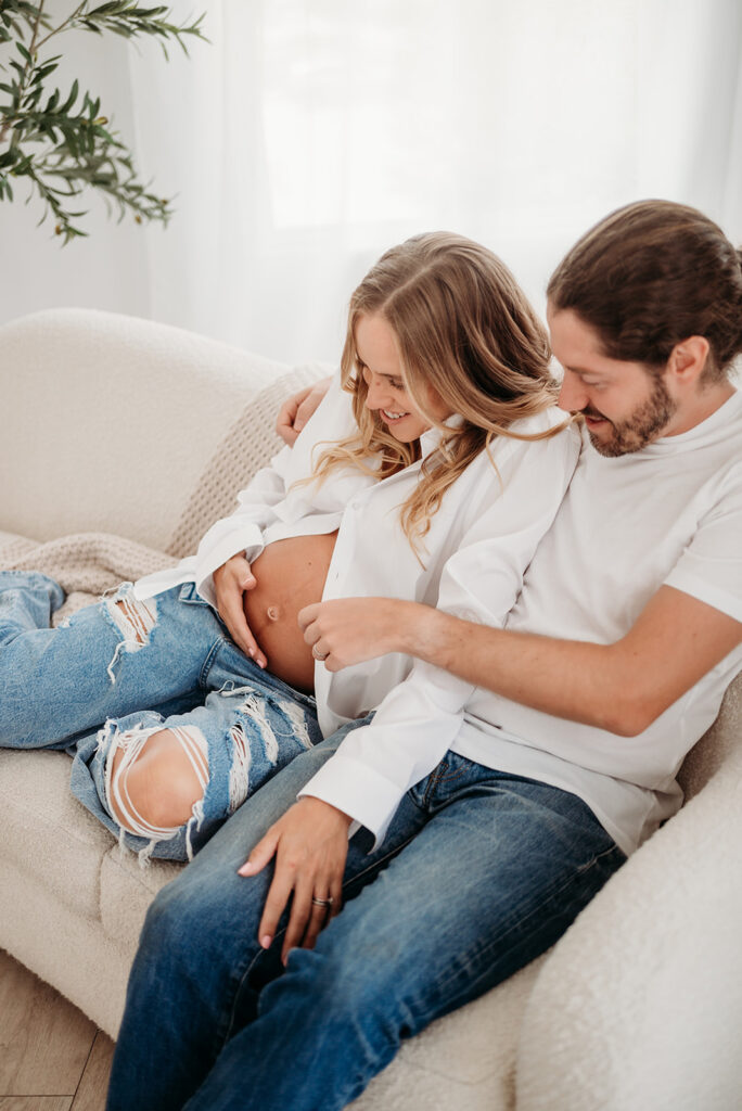 husband touches wife's belly in atlanta maternity session